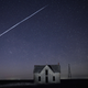 A streak of SpaceX StarLink satellites passes over an old stone house in Kansas.